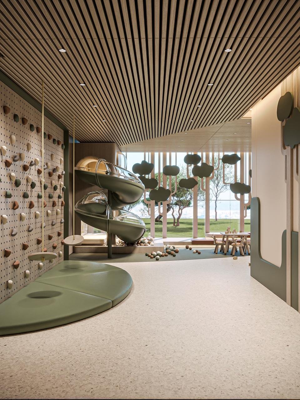 Salle de jeux intérieure pour enfants avec mur d’escalade et toboggan au projet Cybel by Wadan à Dubai Land Residence Complex